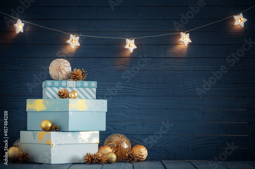 Christmas gifts with golden decorations on blue wooden background