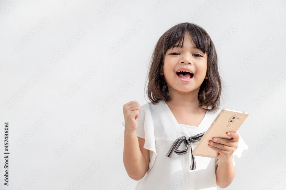 Excited Asian little girl is using a smartphone, empty space shot isolated on white background Excited Asian little girl is using a smartphone, empty space shot isolated on white background