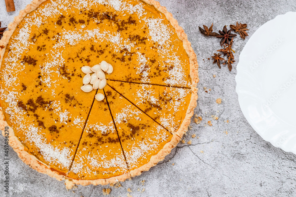 Delicious homemade American pumpkin pie. on a gray and woody background.