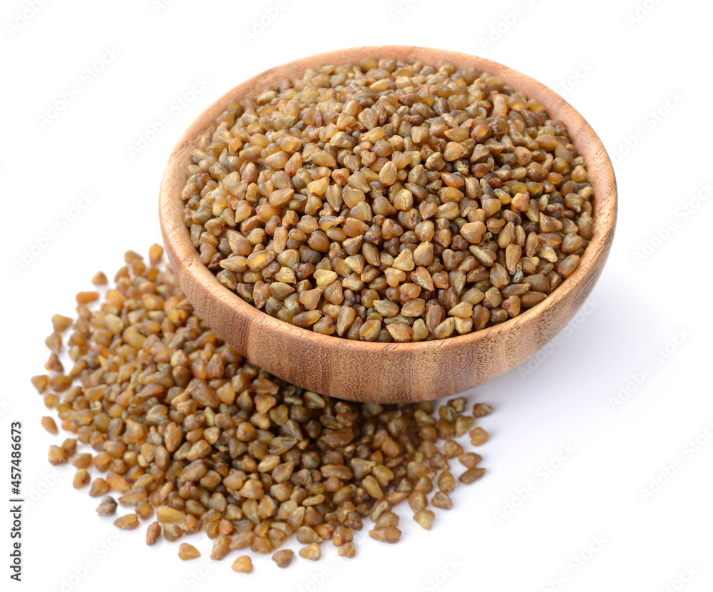 uncooked bitter buckwheat in the wooden bowl, isolated on the white background uncooked bitter buckwheat in the wooden bowl, isolated on the white background
