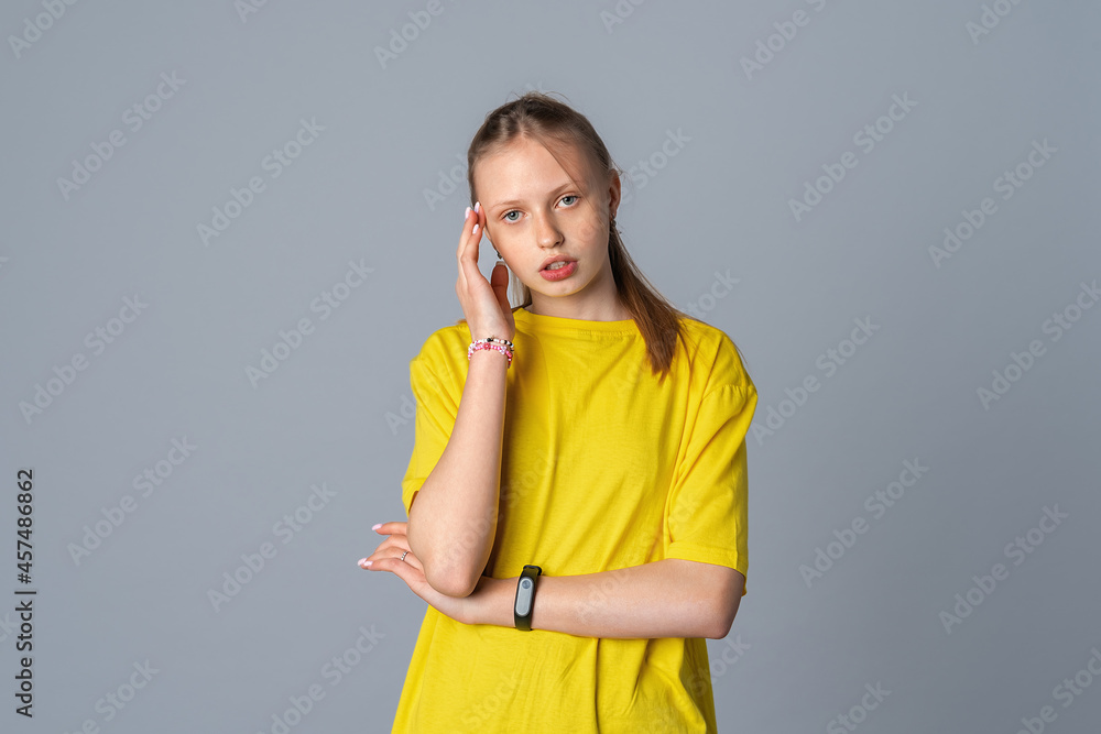 Pretty teen girl suffering from headache isolated on light grey background Pretty teen girl suffering from headache isolated on light grey background