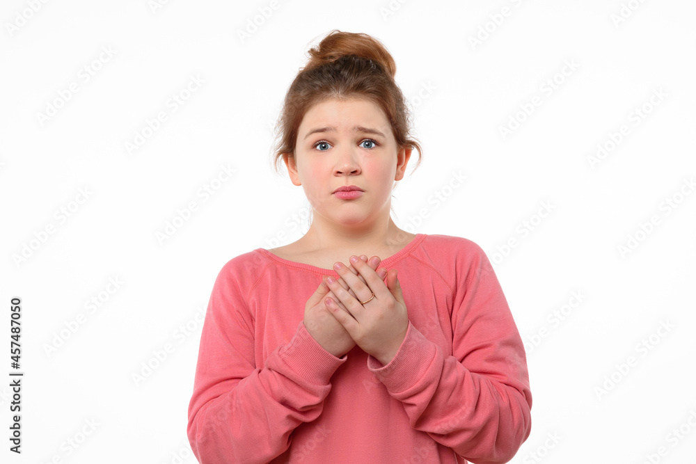 Worried young girl standing white background with a frightened expression on her face. Human emotions concept Worried young girl standing white background with a frightened expression on her face. Human emotions concept