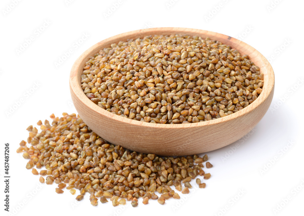 uncooked buckwheat in the wooden plate, isolated on the white background uncooked buckwheat in the wooden plate, isolated on the white background