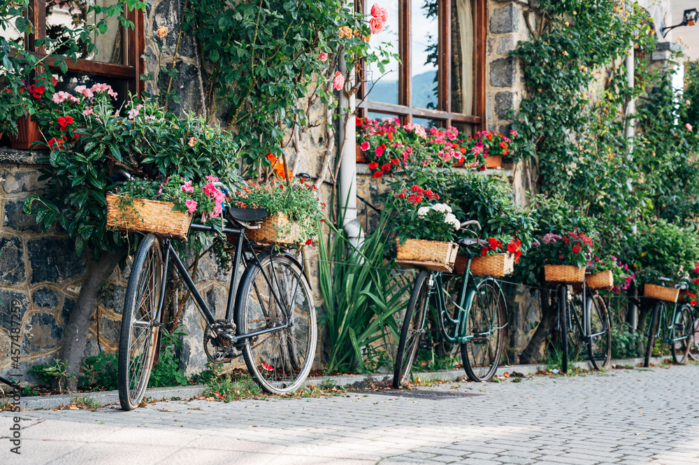 Bicycles in the street with flowers. Horizontal shot of a facade with bicycles