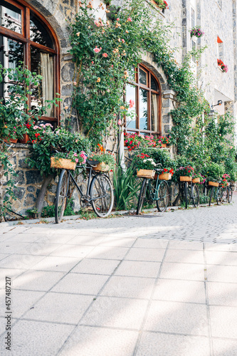 Bicycles in the street with flowers. Vertical shot of a facade with bicycles