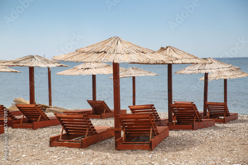 Beach with umbrellas and sun loungers by the sea on a sunny day, Montenegro.