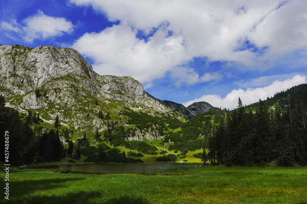 mountain lake with grees grass and mountains with blue sky mountain lake with grees grass and mountains with blue sky