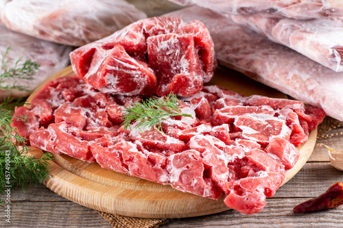 Frozen raw meat in a plastic bag on a table. Frozen pork, beef, chicken. Frozen food.