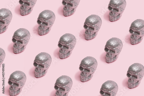 Sparkling skulls scary minimal pattern arrangement. Baby pink creepy background