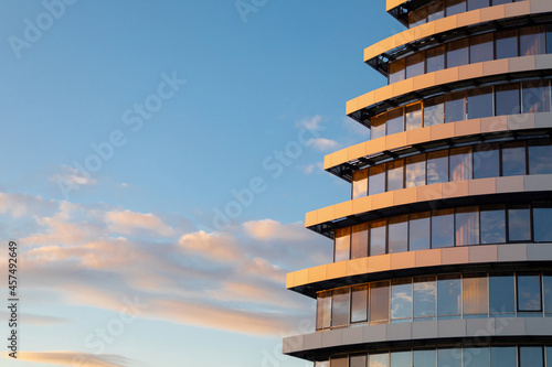 Obraz na płótnie Fragment of modern glass facade of the building under construction against background of sky with clouds
