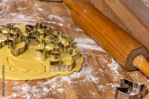 Fancy shaped cookie cutters on rolled fresh pastry photo