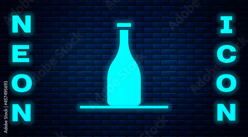 Glowing neon Bottle of wine icon isolated on brick wall background. Vector