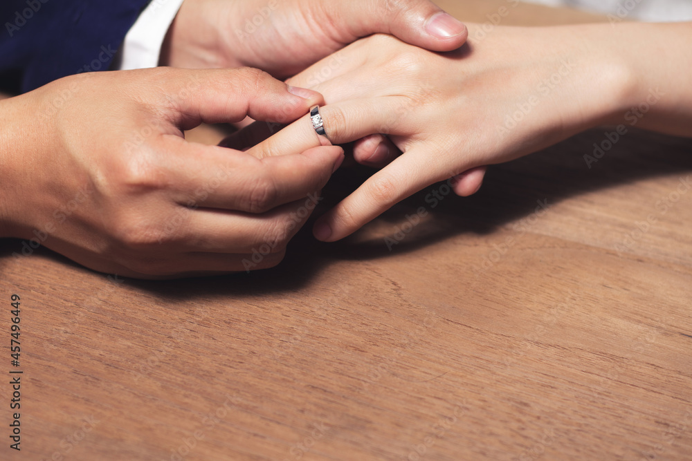 Man wearing the wedding ring to woman finger.