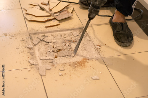 Worker are removing broken tiles for repair.