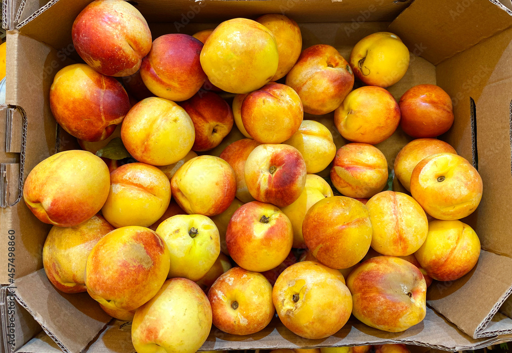 Fresh nectarines in a cardboard box. Top view.