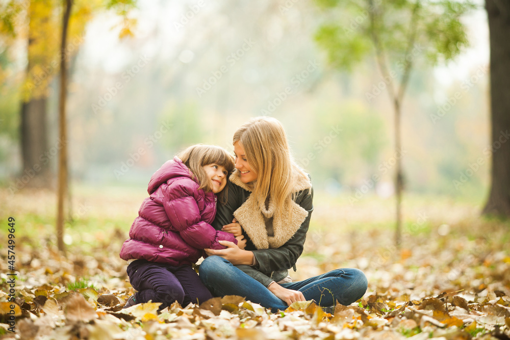 Mother and daughter are embracing in park in autumn. Mother and daughter are embracing in park in autumn.