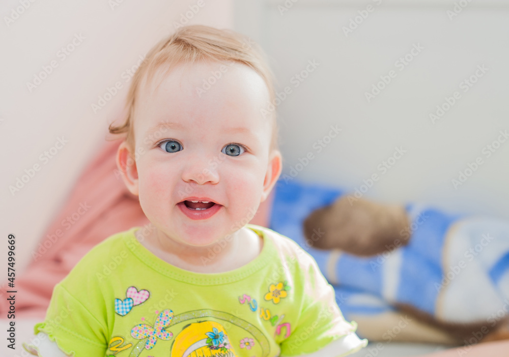 Full length of a baby girl smiling while sitting on the bed at home. Child, happiness and people concept - adorable baby Full length of a baby girl smiling while sitting on the bed at home. Child, happiness and people concept - adorable baby