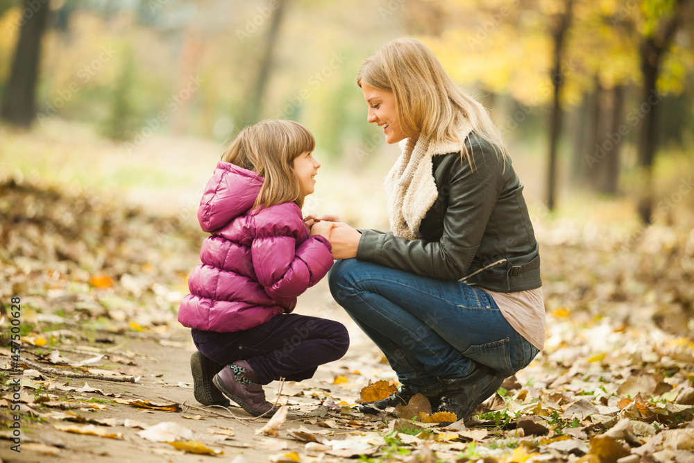 Mother and daughter are having fun in park in autumn. Mother and daughter are having fun in park in autumn.