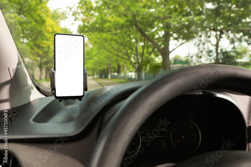 Car holder with modern mobile phone on windshield of automobile. Mockup for design photo