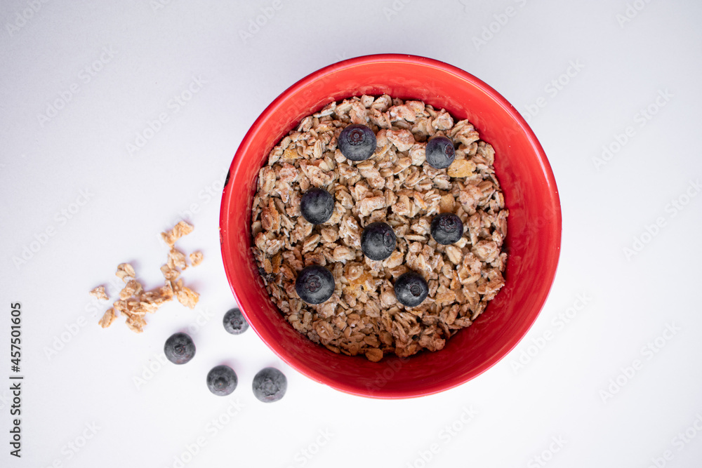 red bowl with cereals and blueberries red bowl with cereals and blueberries