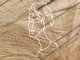 Szkic twarzy kobiety na drewnianym tle.