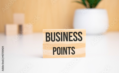 On a light background, wooden cubes and a wooden block with the text business points. View from above