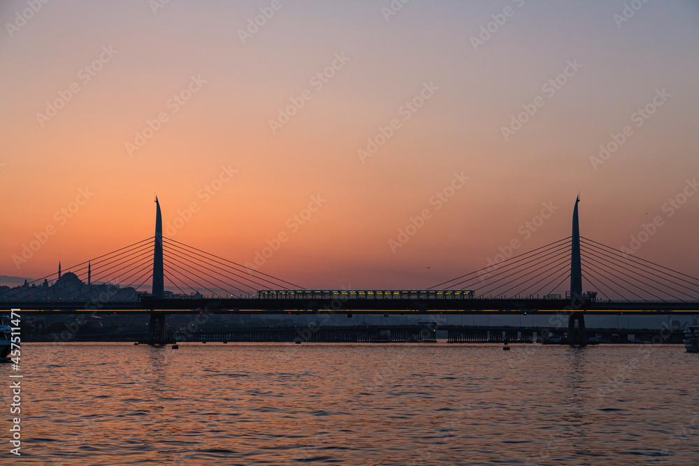 Fototapeta premium トルコ イスタンブールの金角湾にかかる新市街と旧市街をつなぐ橋と夕焼けでオレンジに染まった空