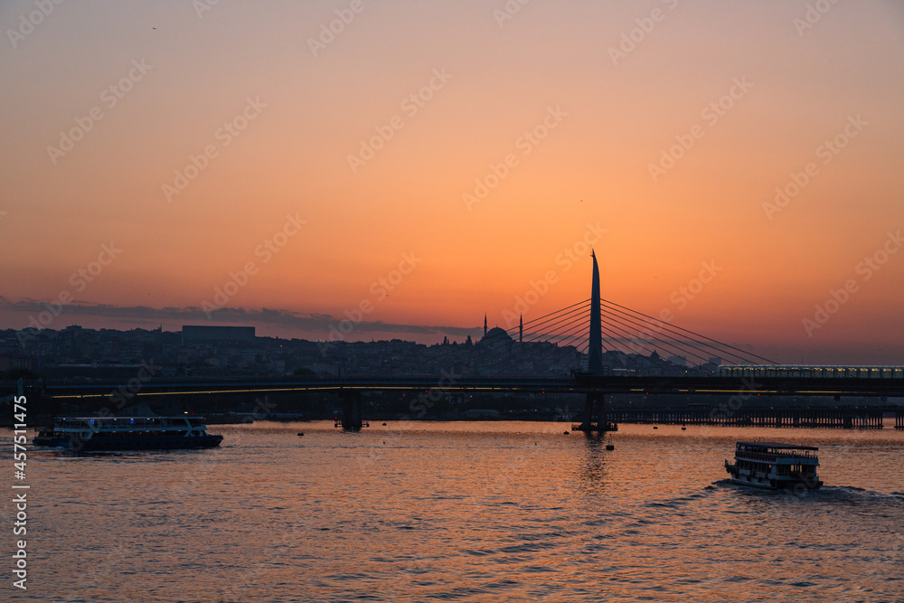 トルコ　イスタンブールの金角湾にかかる新市街と旧市街をつなぐ橋と夕焼けでオレンジに染まった空