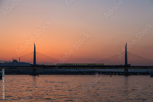 トルコ イスタンブールの金角湾にかかる新市街と旧市街をつなぐ橋と夕焼けでオレンジに染まった空
