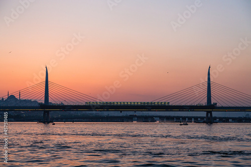 Fototapeta Naklejka Na Ścianę i Meble -  トルコ　イスタンブールの金角湾にかかる新市街と旧市街をつなぐ橋と夕焼けでオレンジに染まった空