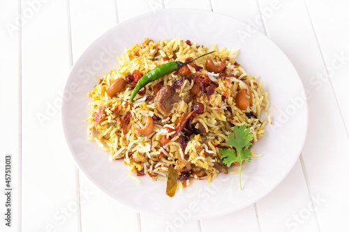 Halal Indian chicken Biryani with chili on plate. White wooden background. Selective focus. Top view.
