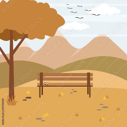 Panoramic landscape in autumn with a lonely bench. Two glasses of coffee on the bench. Birds flying away to warm lands. Mountains in the distance in autumn.