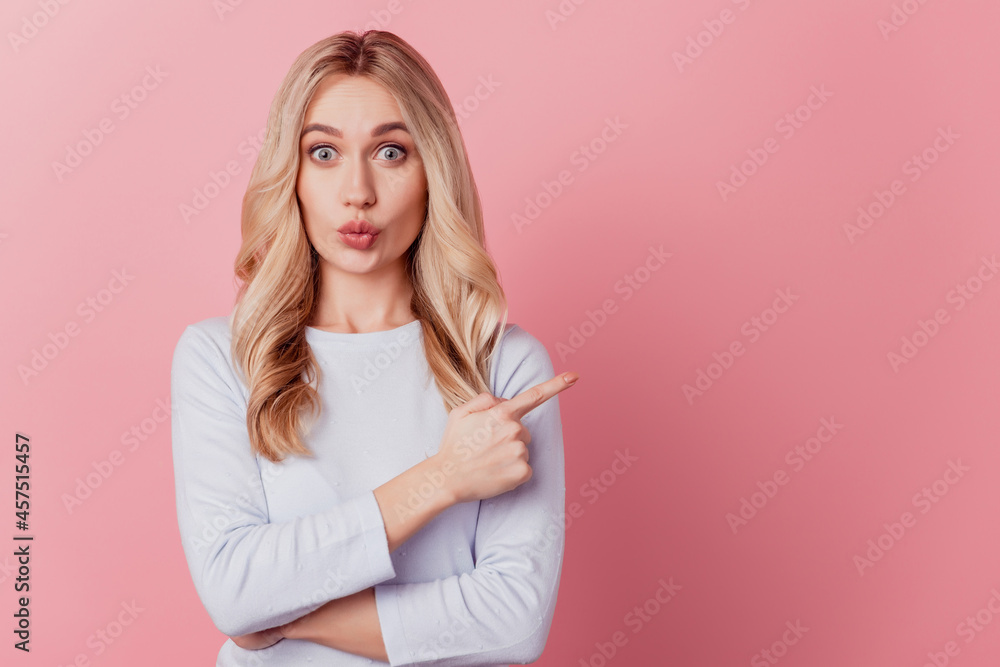 Portrait of excited funny cute lady direct finger empty space on pink background Portrait of excited funny cute lady direct finger empty space on pink background