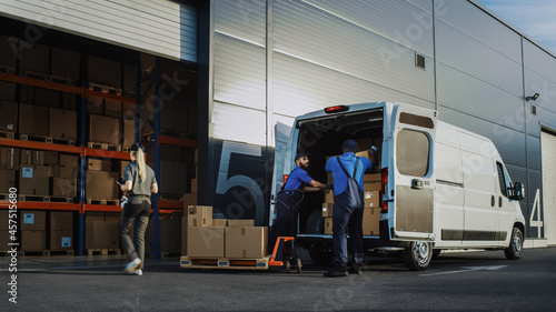 Outside of Logistics Distributions Warehouse With Manager Using Tablet Computer, Workers Start Loading Delivery Truck with Cardboard Boxes. Online Orders, Purchases, E-Commerce Goods.
