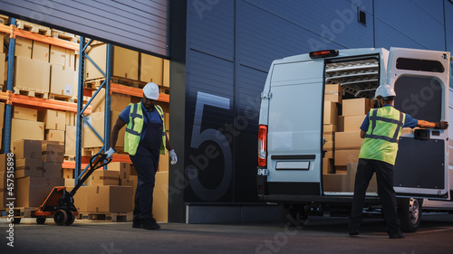 Logistics Warehouse Two Happy Workers Talk, Joke use Hand Pallet Truck Start Loading Delivery Truck with Cardboard Boxes, Online Orders, Purchases, E-Commerce Goods.