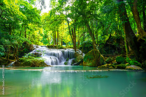 Waterfalls and fish swim in the emerald blue water in Erawan National Park. Erawan Waterfall is a beautiful natural rock waterfall in Kanchanaburi, Thailand.Onsen atmosphere. soft focus.