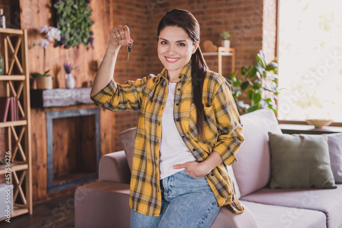 Photo of young happy cheerful positive woman hold hand keys jeans pocket relocation mortgage indoors inside house home