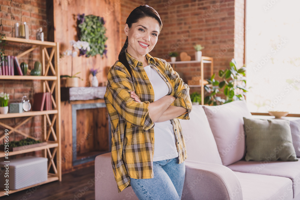 Photo of young cheerful positive confident woman smile good mood hands crossed inside house home apartment Photo of young cheerful positive confident woman smile good mood hands crossed inside house home apartment