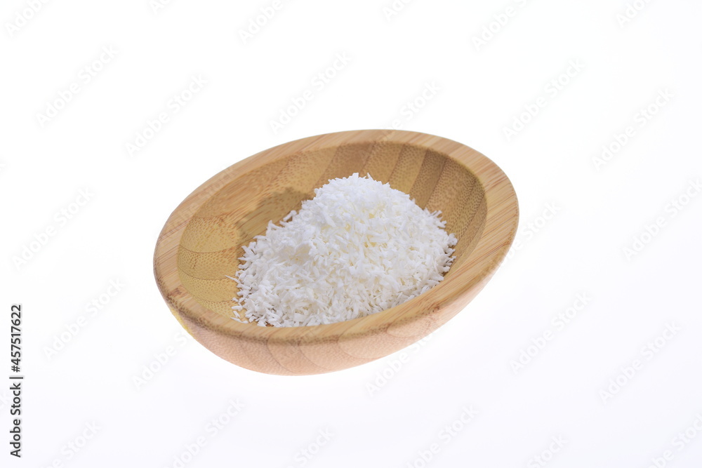 Coconut shavings in a wooden bowl against a white background. Food. Coconut shavings in a wooden bowl against a white background. Food.