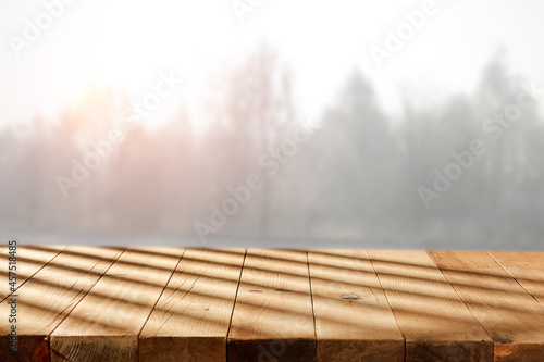 A wooden table, a pedestal, on a beautiful cold morning and shadows of the sun 
