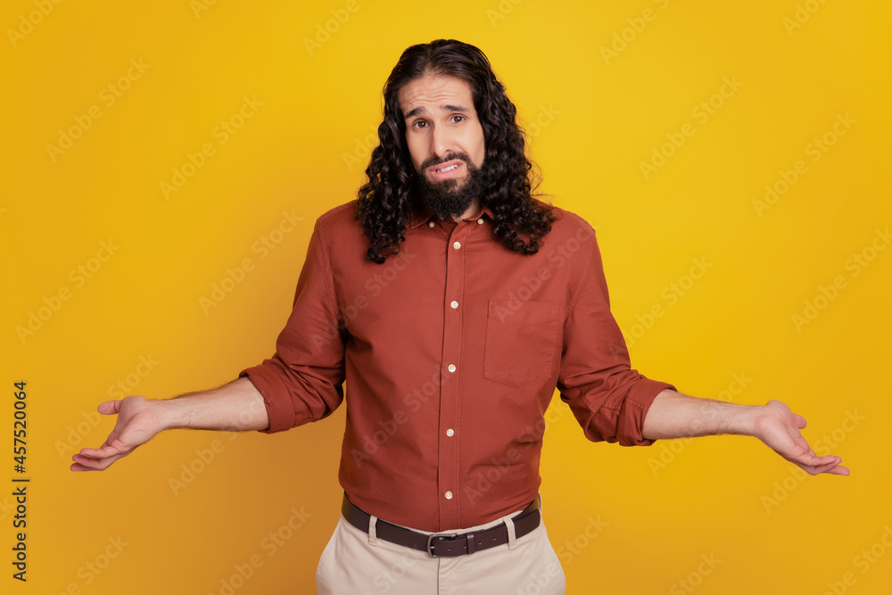 Portrait of clueless guy have doubts shrug shoulders on yellow background Portrait of clueless guy have doubts shrug shoulders on yellow background
