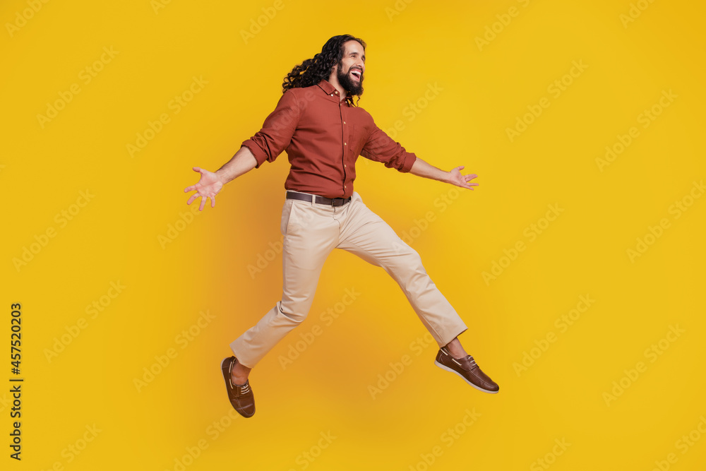 Portrait of cheerful funky guy jump enjoy have fun on yellow background
