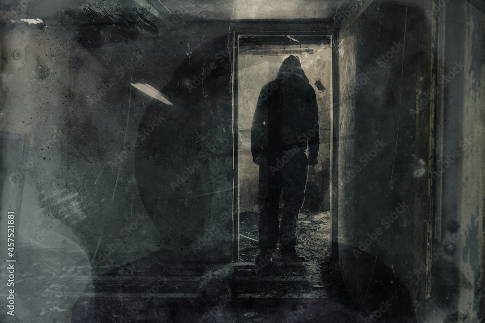 A double exposure of a scary hooded figure standing in the doorway of a ruined building. With a grunge, texture vintage edit. A double exposure of a scary hooded figure standing in the doorway of a ruined building. With a grunge, texture vintage edit.