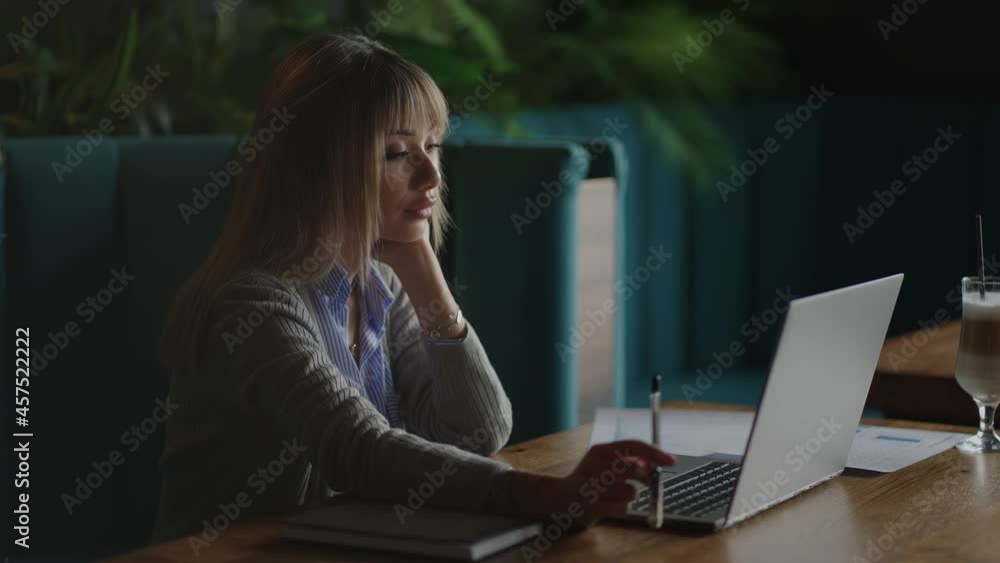 An Asian woman student writes an online lecture on campus with a pen. Sitting in the library, a Korean woman student listens to a lecture An Asian woman student writes an online lecture on campus with a pen. Sitting in the library, a Korean woman student listens to a lecture