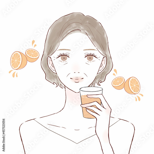 オレンジジュースを飲む中年女性