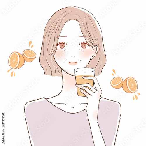 オレンジジュースを飲む中年女性