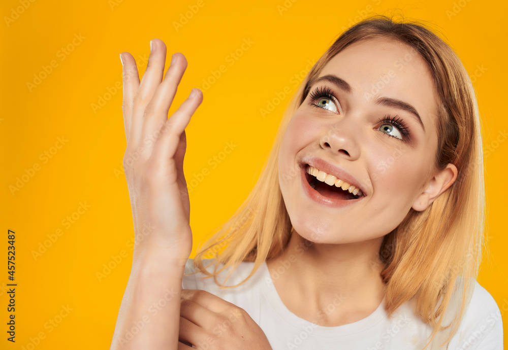 beautiful blonde in a white t-shirt hand gesture Studio Model close-up beautiful blonde in a white t-shirt hand gesture Studio Model close-up