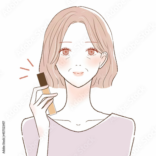 コンシーラーを持つ中年女性
