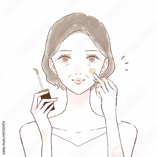 コンシーラーを顔に塗る中年女性