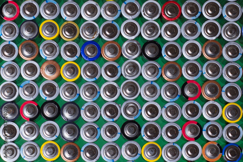 several alkaline batteries on top of each other on a green background